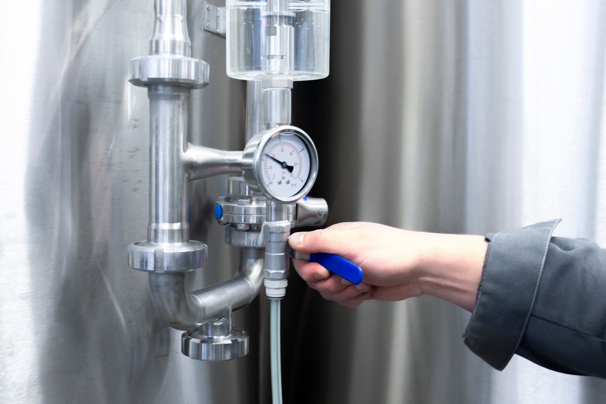 a handyman turning the tube valve on the factory